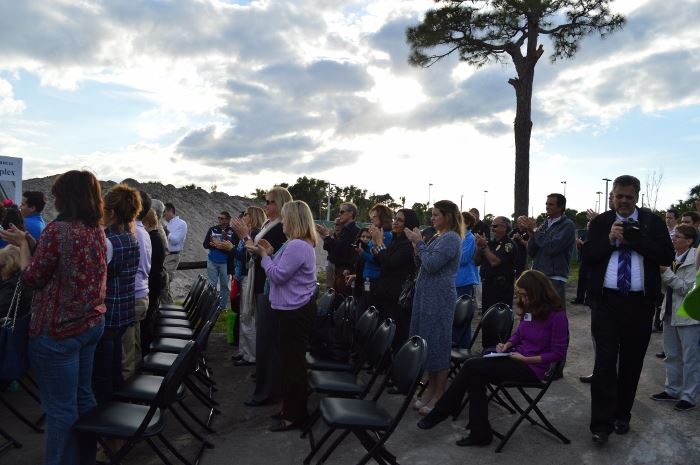 A crowd of people standing and clapping